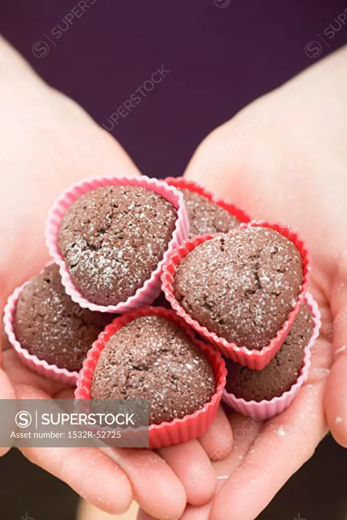 Woman holding heart-shaped chocolate buns