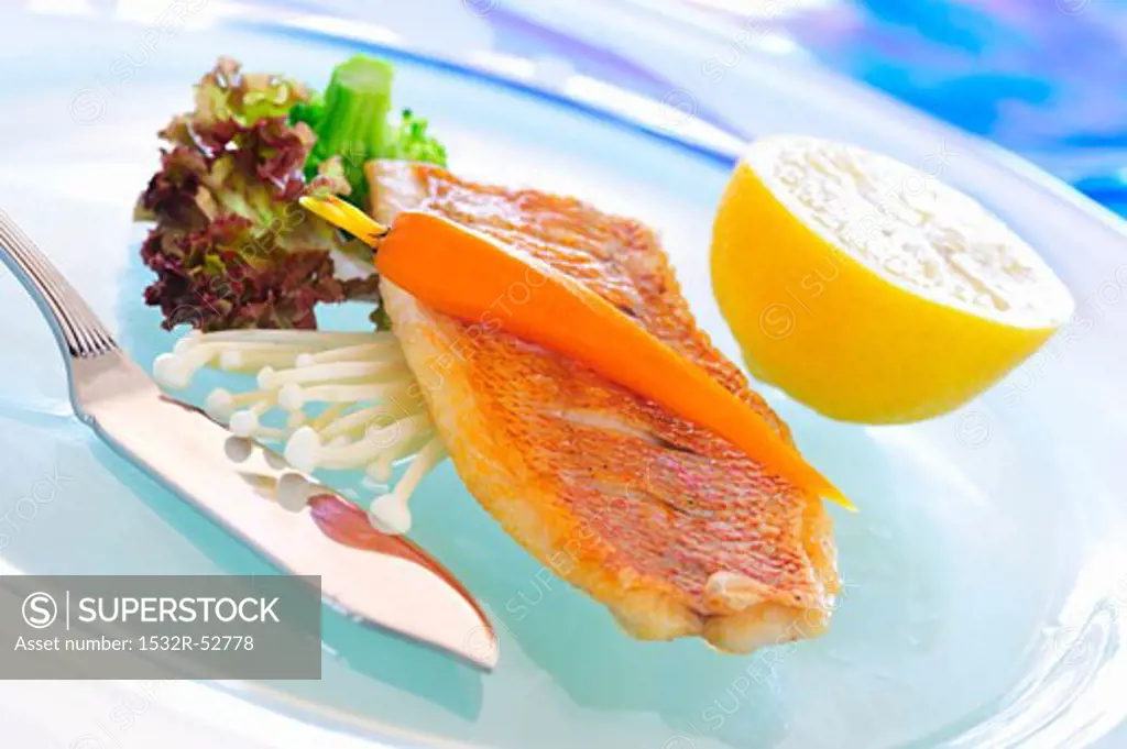 Fried red snapper with carrot on enokitake mushrooms