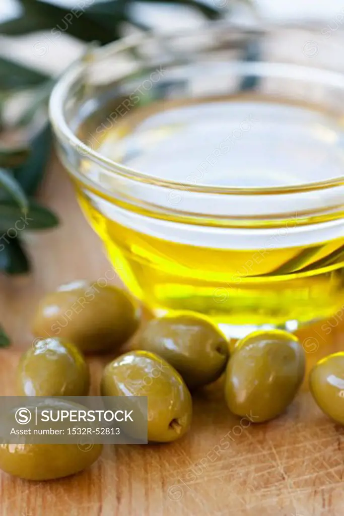 Green olives and a small bowl of olive oil