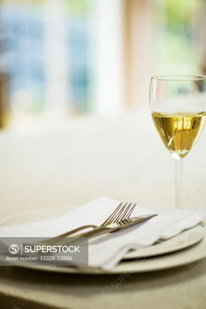 Place-setting and glass of white wine