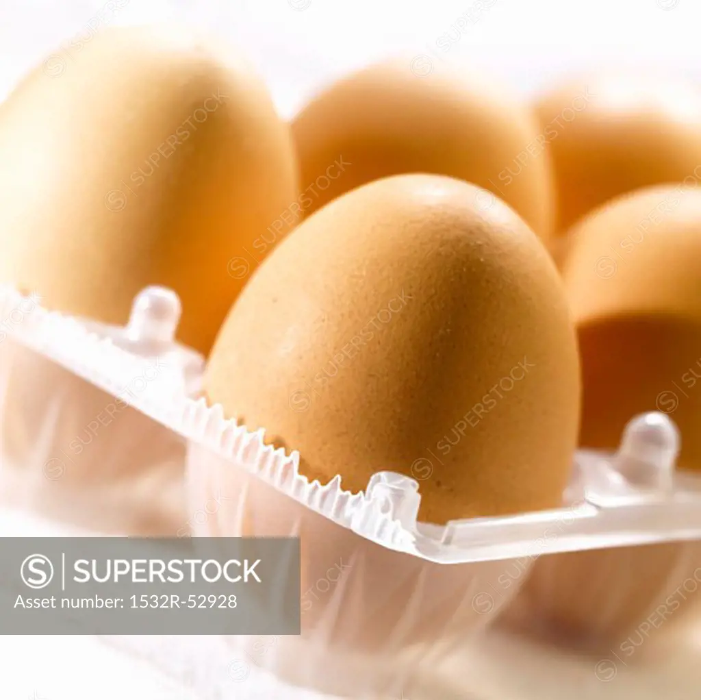 Several brown eggs in an egg box