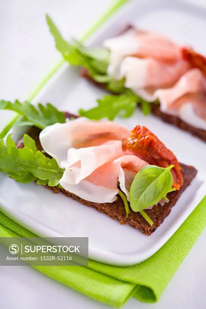 Raw ham, rocket and dried tomatoes on wholemeal bread