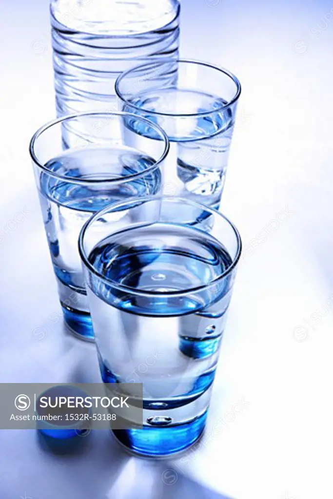 Three glasses of mineral water with bottle