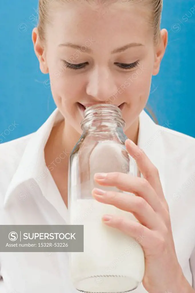 Young woman drinking milk out of the bottle