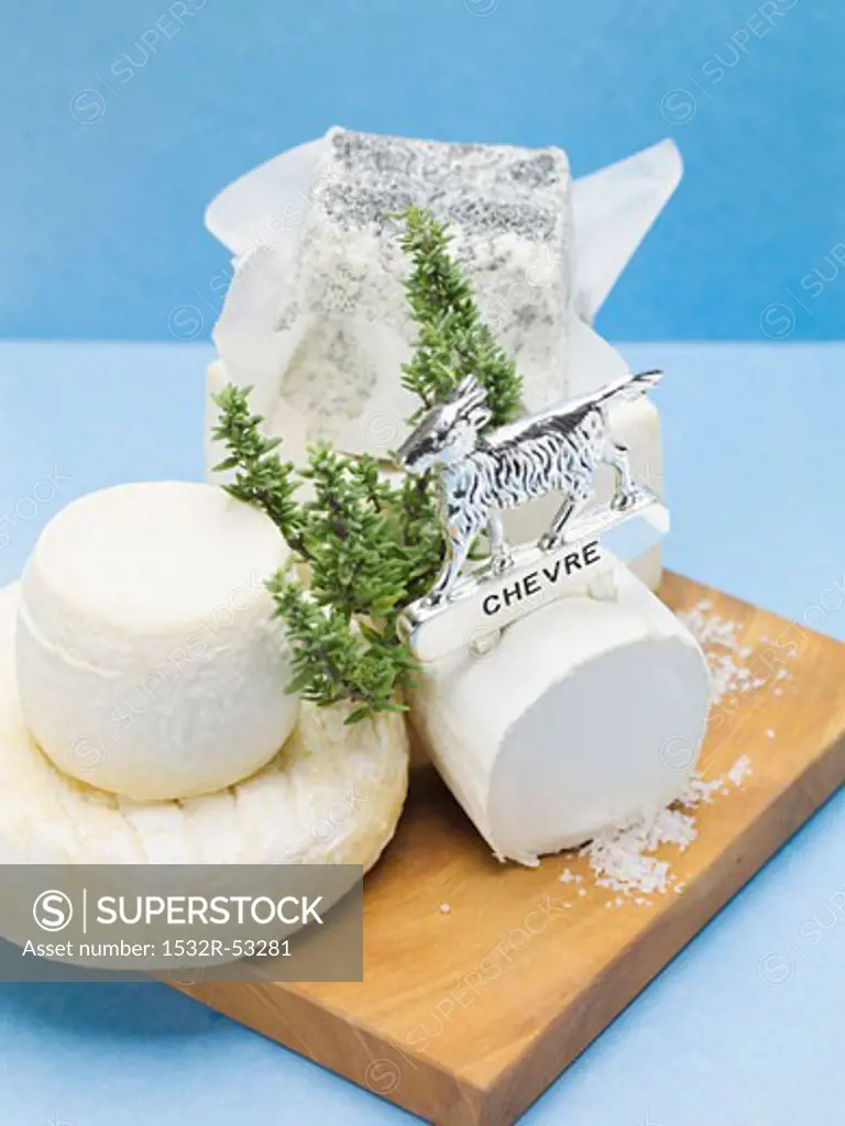 Various goat's cheeses on chopping board