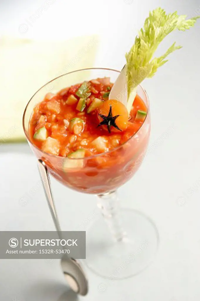 Vegetable soup in a glass with a spoon