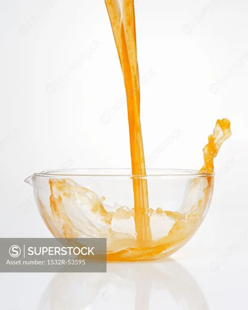 Pouring fruit juice into a glass bowl