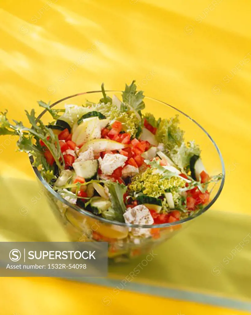 Mixed salad with sheep's cheese in glass bowl