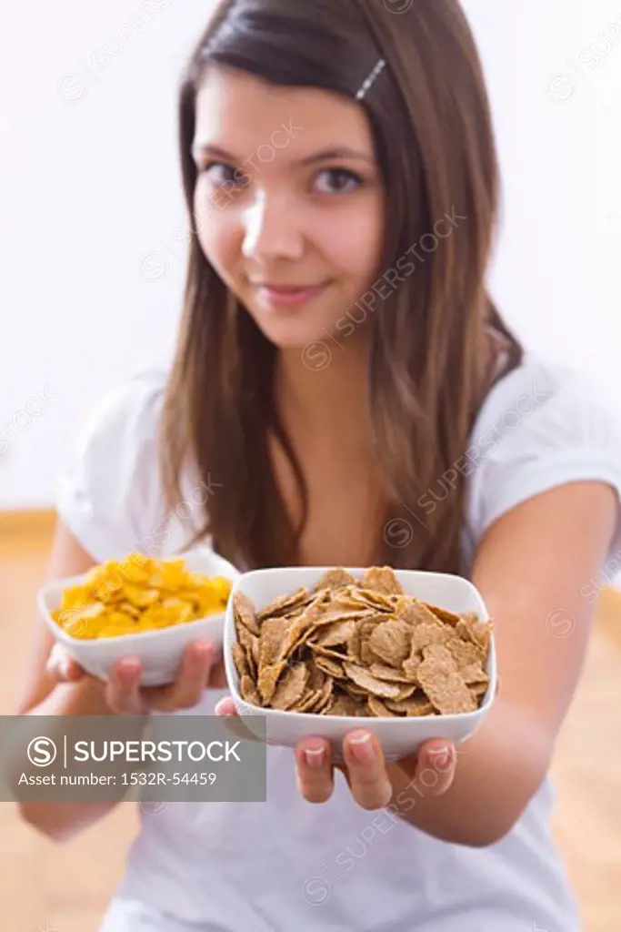 Girl holding two bowls of cornflakes