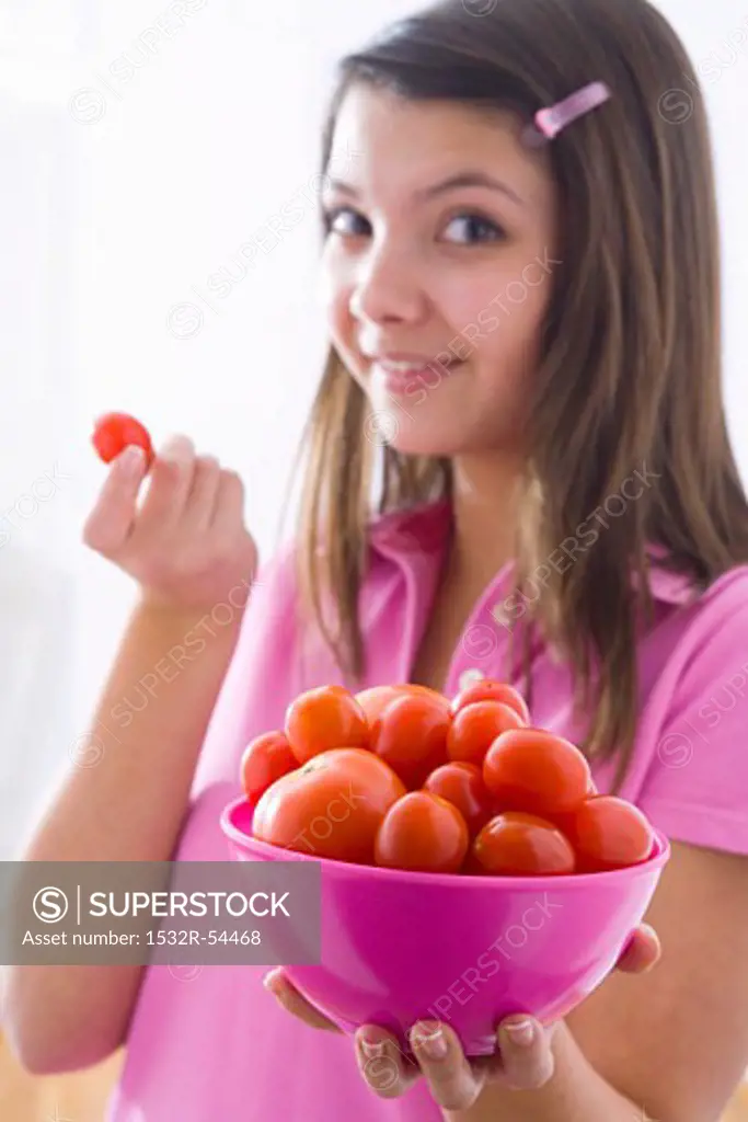 Girl holding a bowl of tomatoes