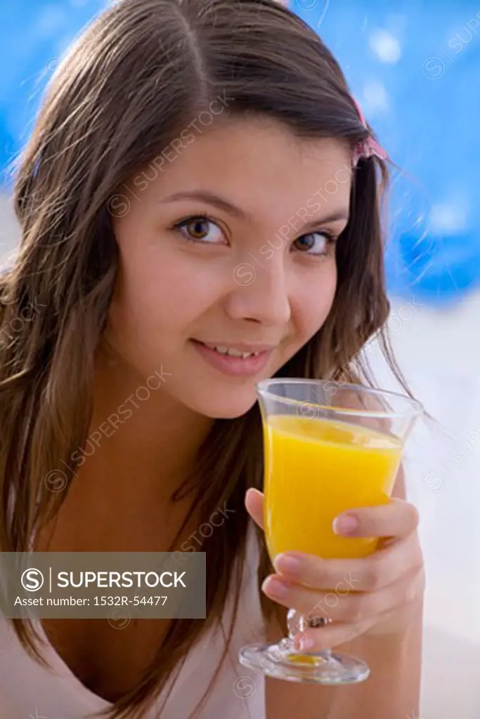 Girl holding a glass of orange juice