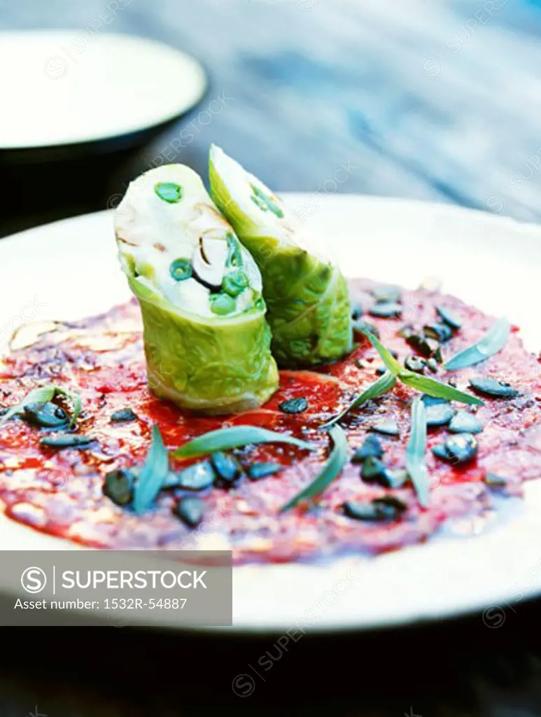 Vegetable polenta wrapped in savoy cabbage on a beef carpaccio