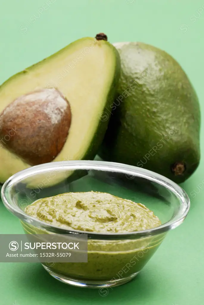 Guacamole with avocados in the background