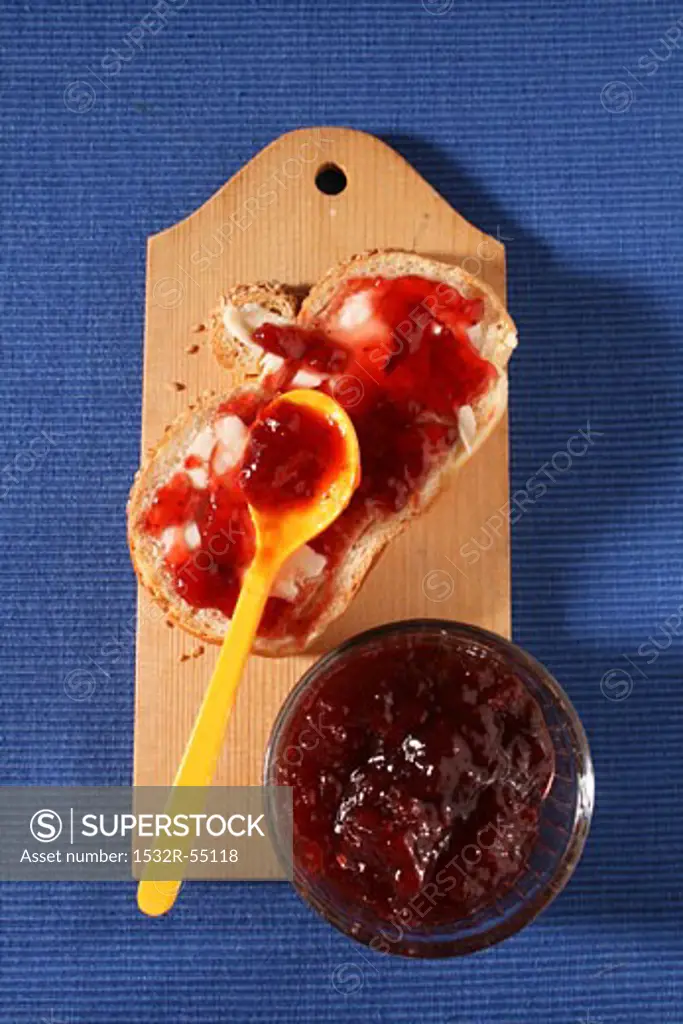Slice of bread and jam with pot of jam