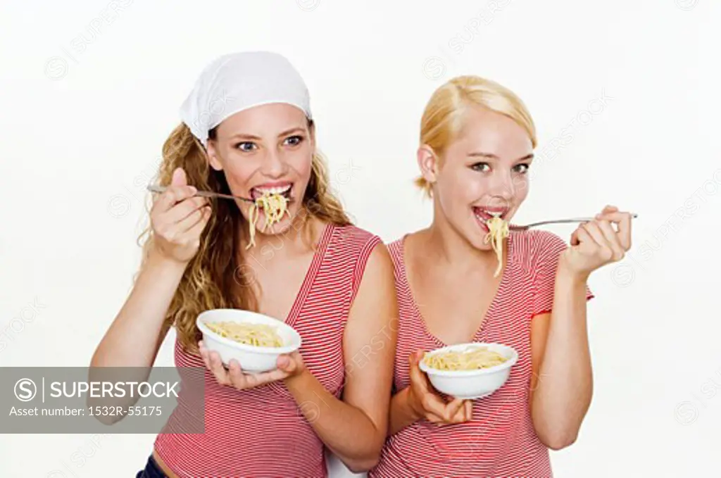 Two women eating spaghetti