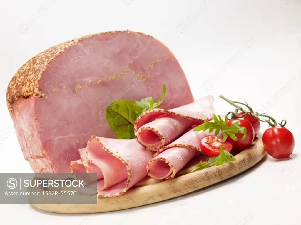 Ham with tomatoes on a wooden board