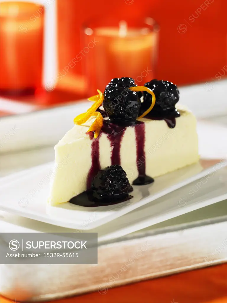 A piece of cheese cake with blackberry sauce
