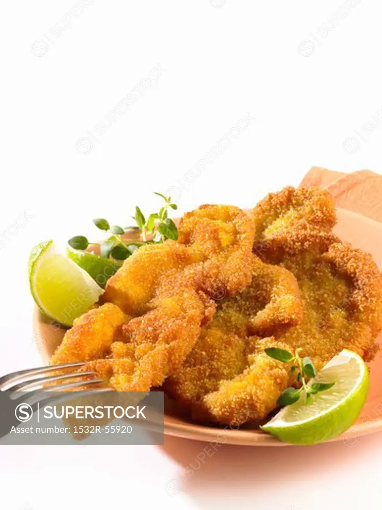 Breaded escalopes with lime wedges