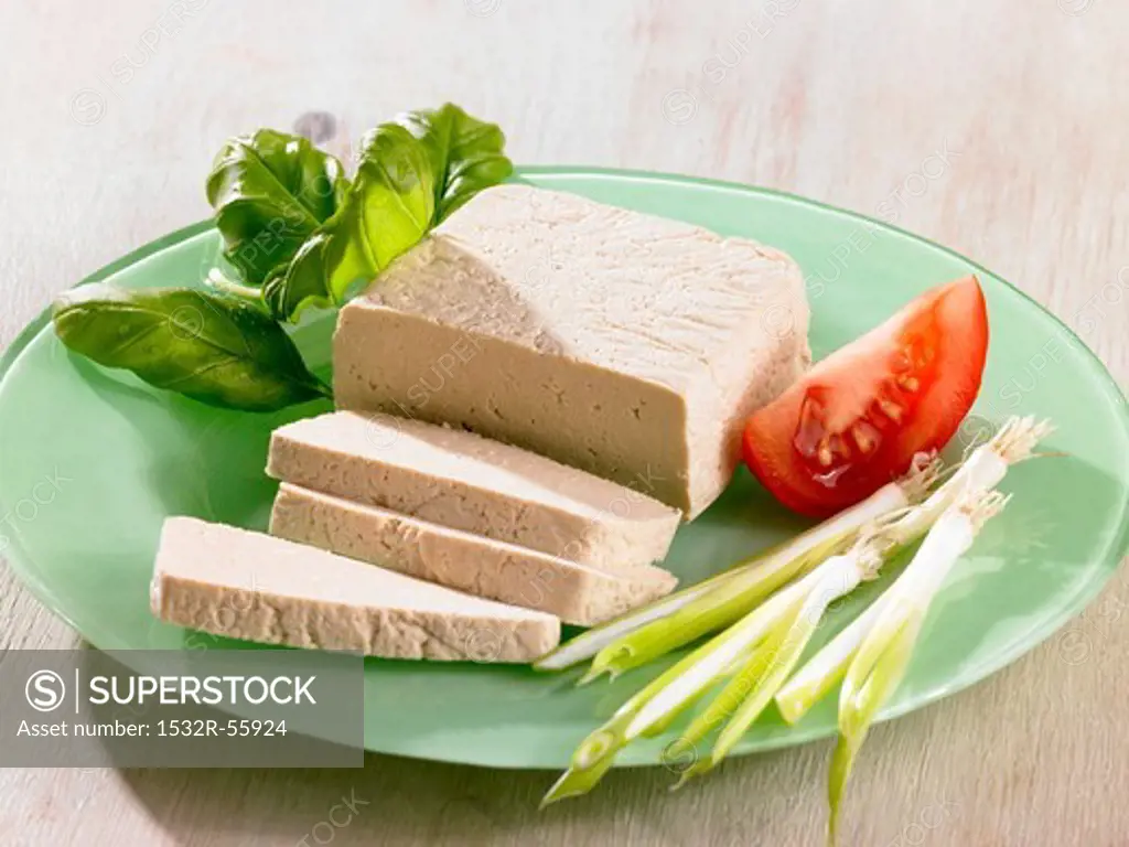 Tofu with basil and vegetables on plate