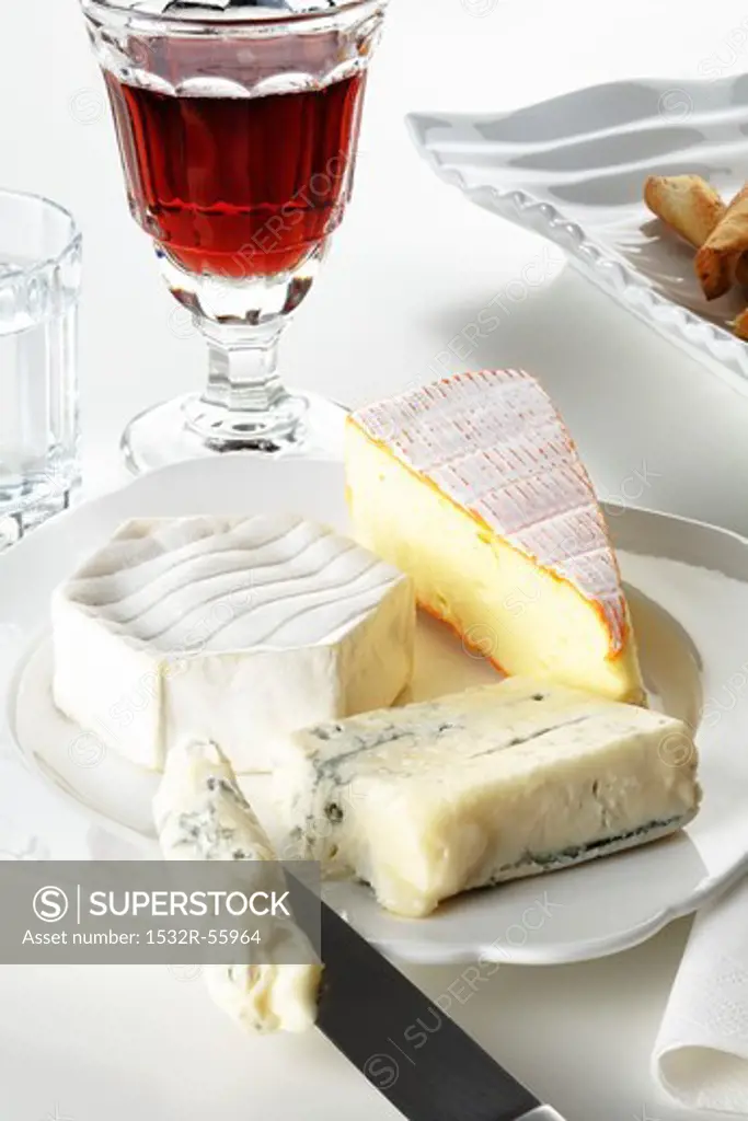 A plate of cheese and a glass of red wine