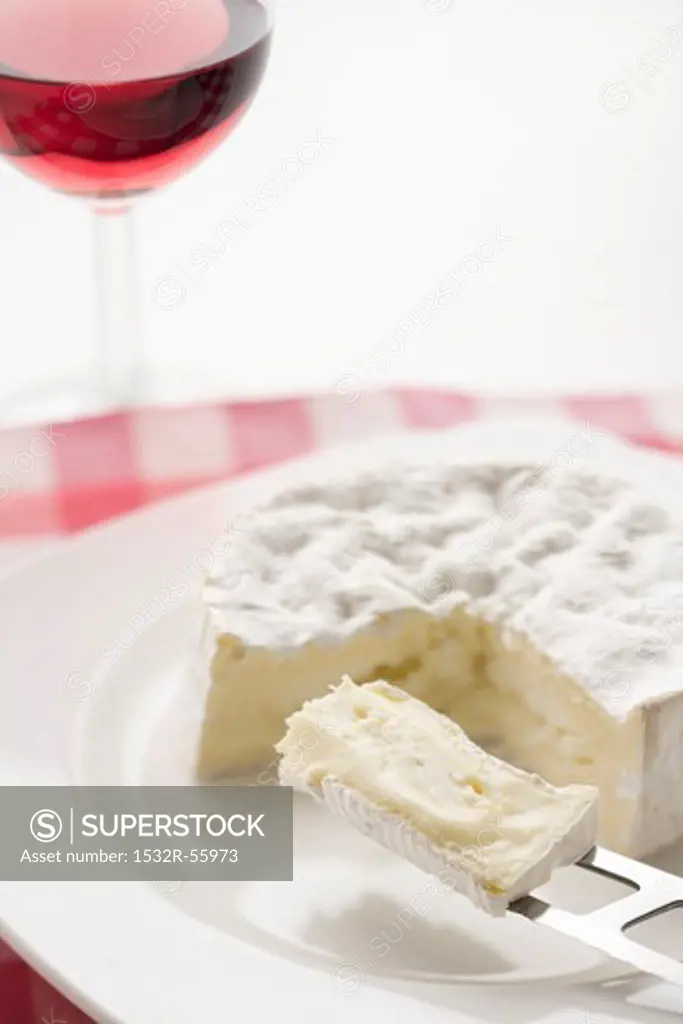 Sliced Camembert and a wine glass