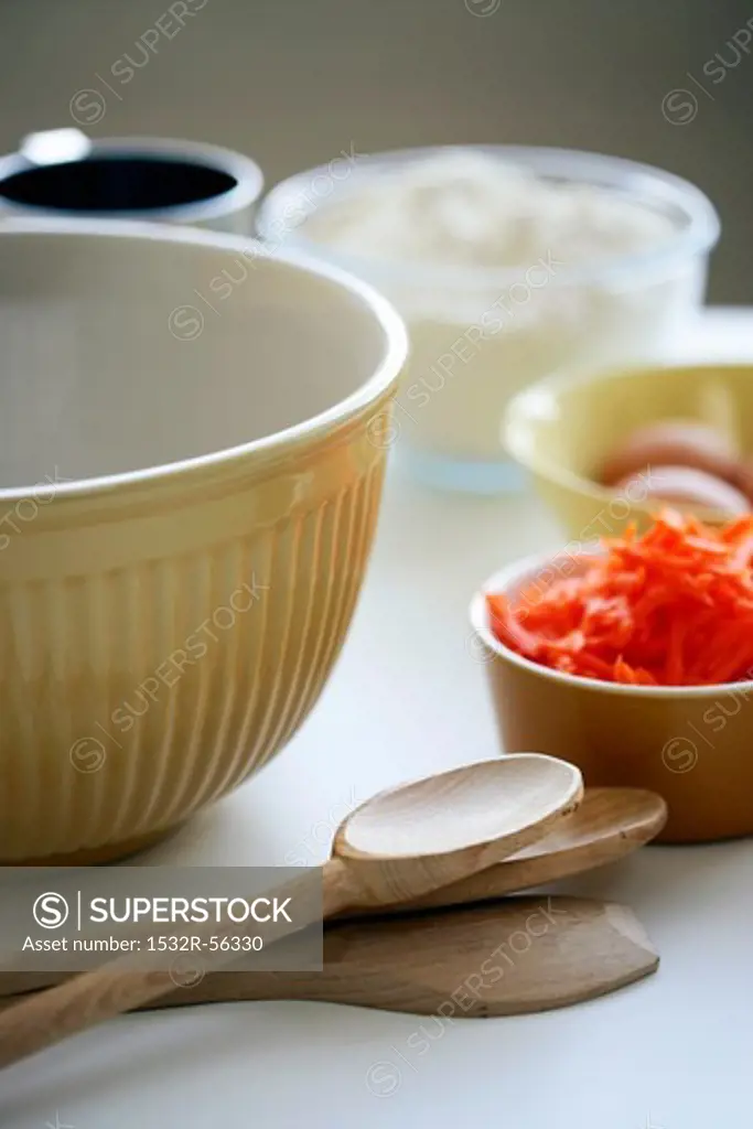 A mixing bowl, wooden spoons and ingredients