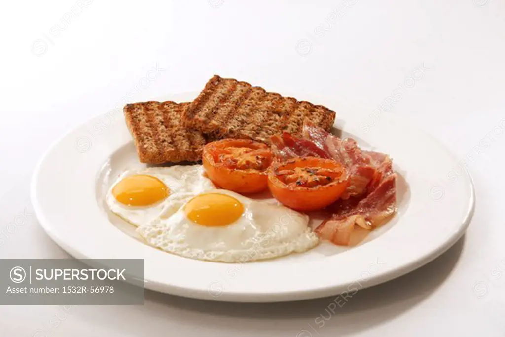 English breakfast (fried egg, bacon, wholemeal toast, tomatoes)