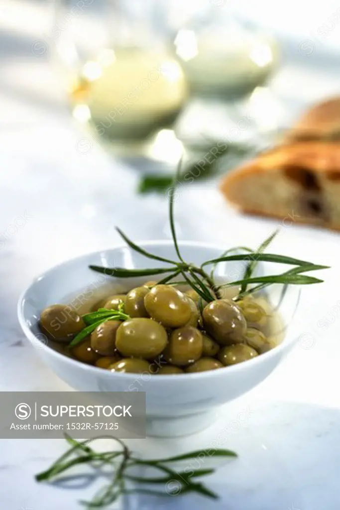 Green olives in olive oil with rosemary