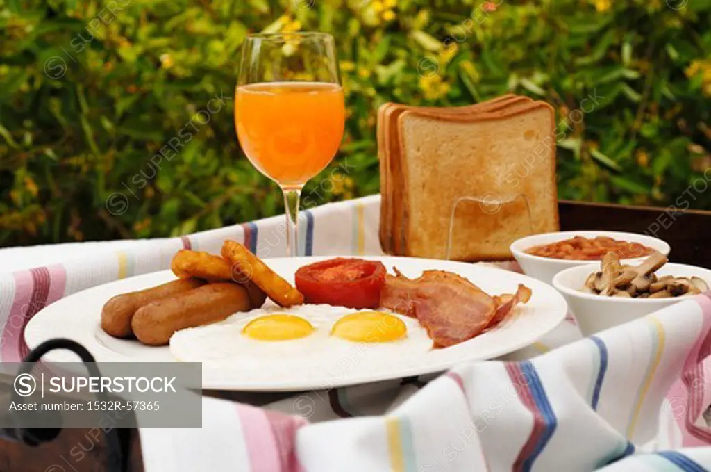 English breakfast with toast and orange juice in the garden
