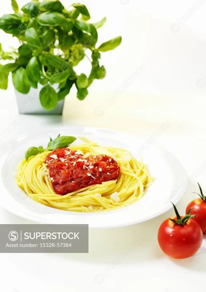 Spaghetti with a heart made of tomato sauce with basil