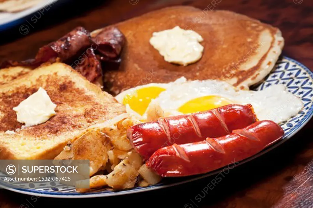 Large Breakfast Plate of French Toast, Home Fries, Sausage, Eggs, Pancakes and Bacon
