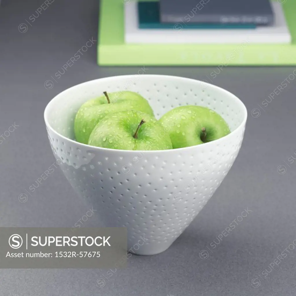 Three apples in a ceramic bowl