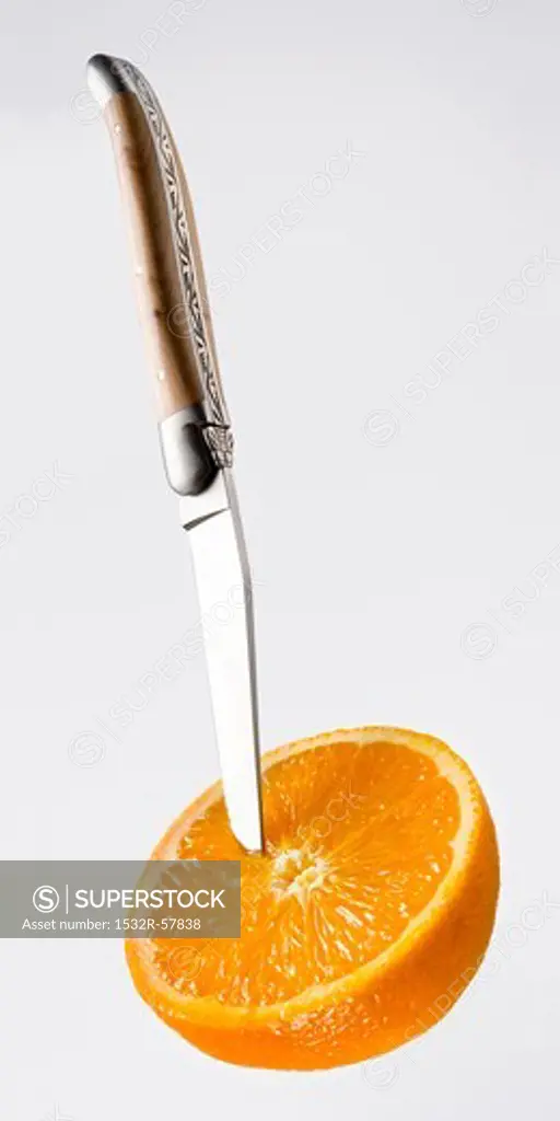 Half an orange with knife