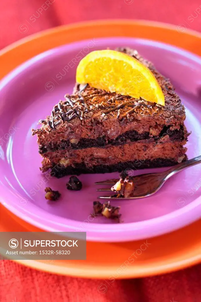 Piece of chocolate mousse cake with a slice of orange