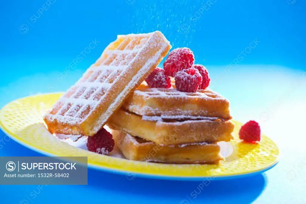 Waffles with raspberries and icing sugar