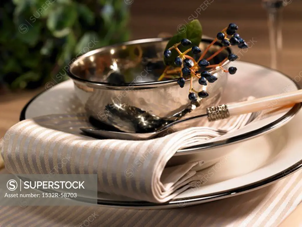 A festive place setting with a silver bowl