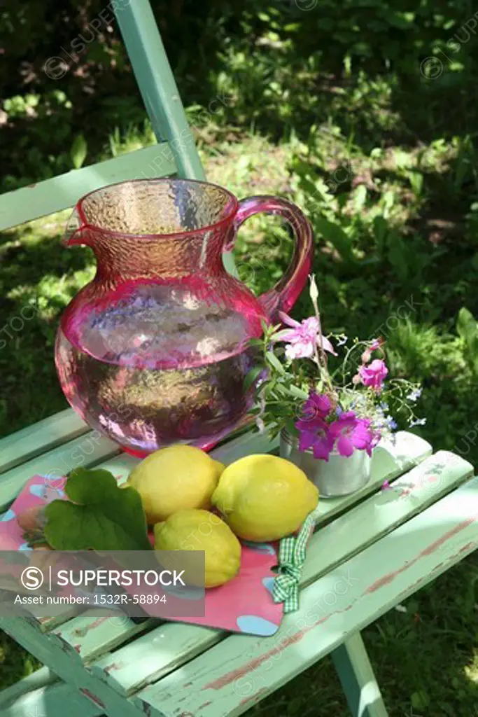 Lemons and a jug of water on a garden chair
