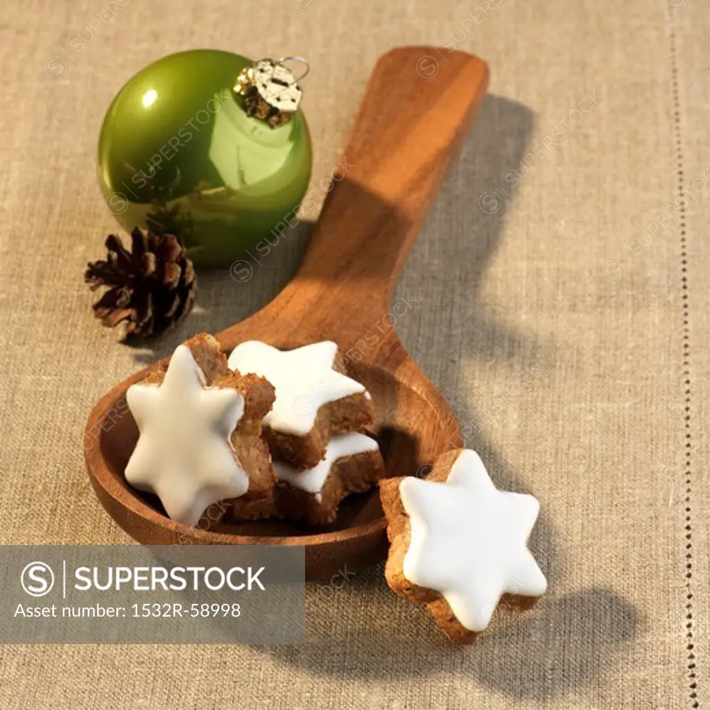 Cinnamon stars on a wooden spoon and Christmas decorations