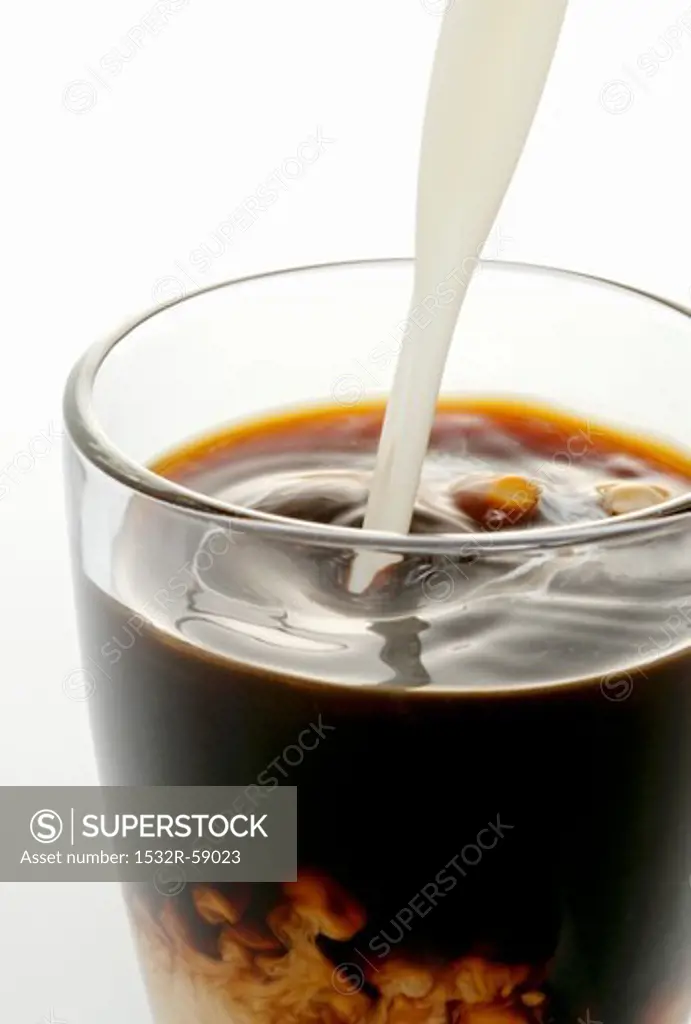 Cream being poured into coffee
