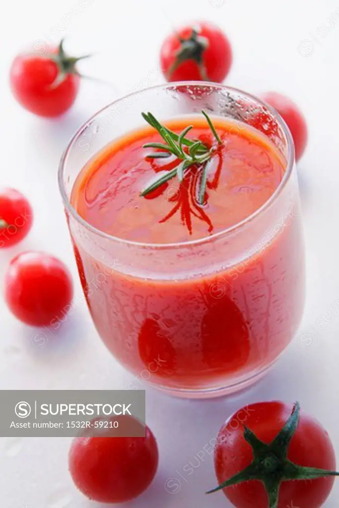A glass of tomato juice with rosemary