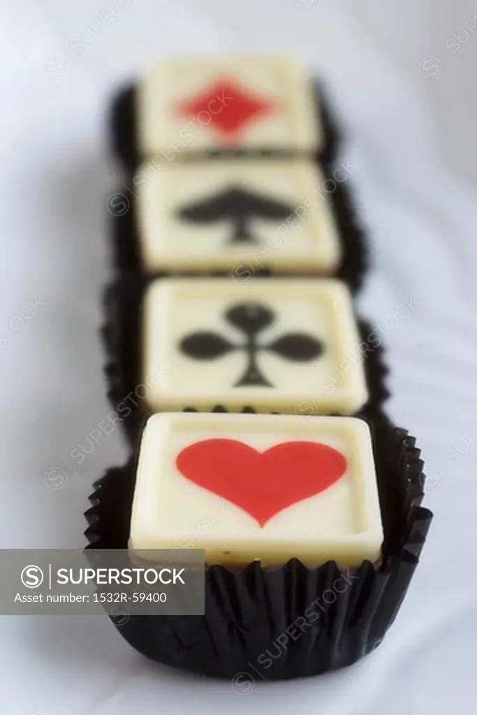 Four pralines with playing card symbols