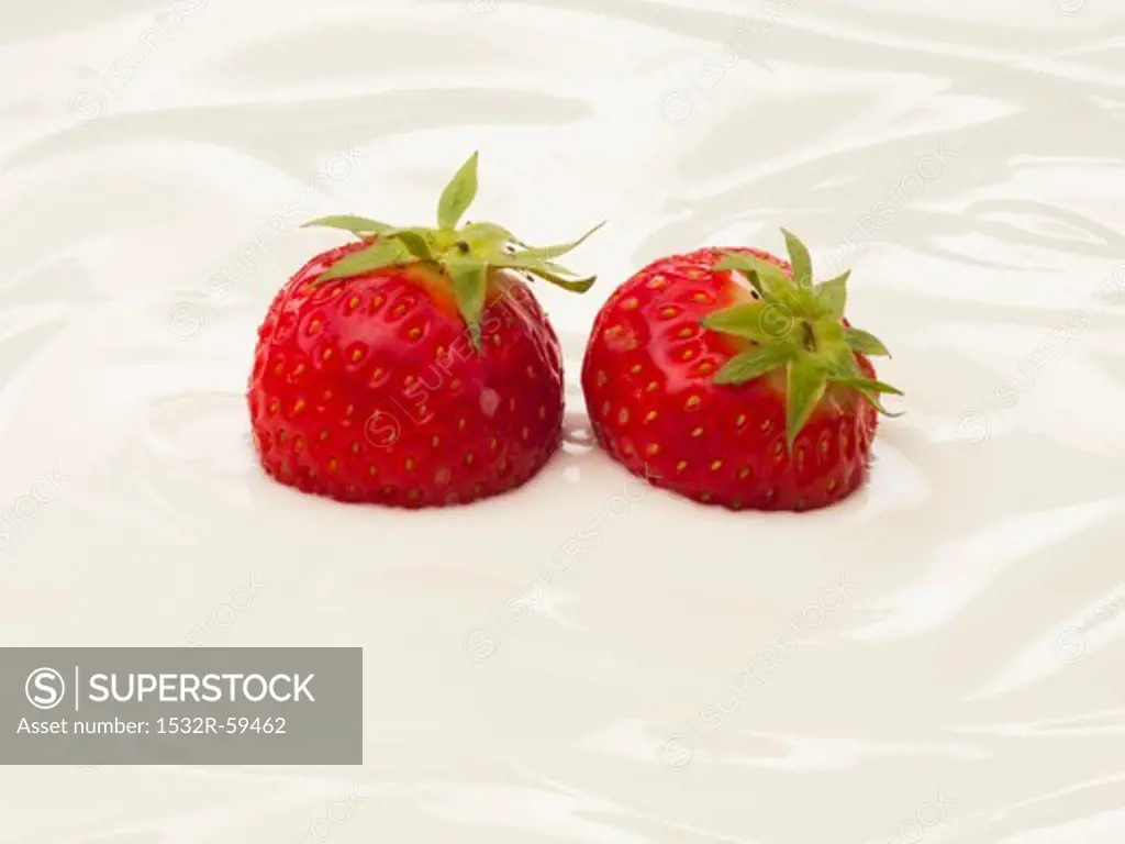 Two strawberries in yogurt