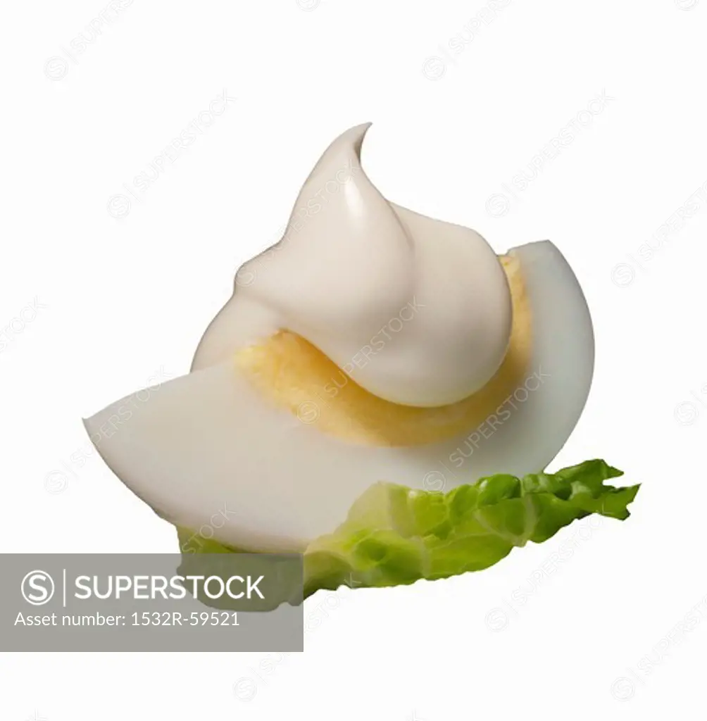 A sliced of boiled egg with a dollop of mayonnaise