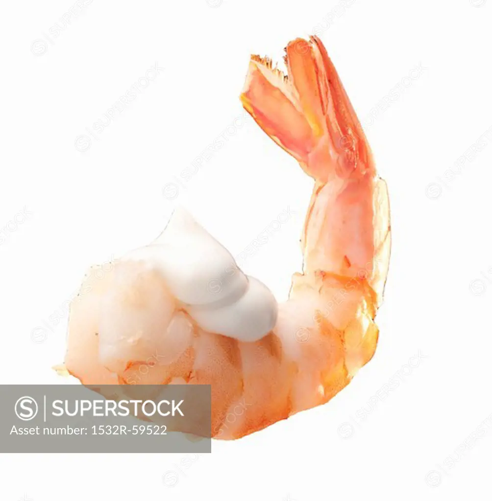 A cooked prawn with a dollop of mayonnaise