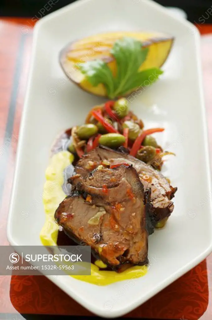 Braised lamb shoulder on turmeric sauce with vegetables and fried mango (Asia)