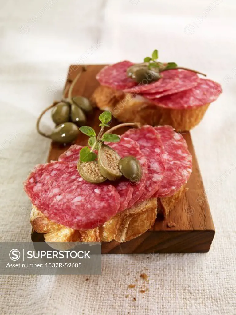 Open sandwiches with salami and capers