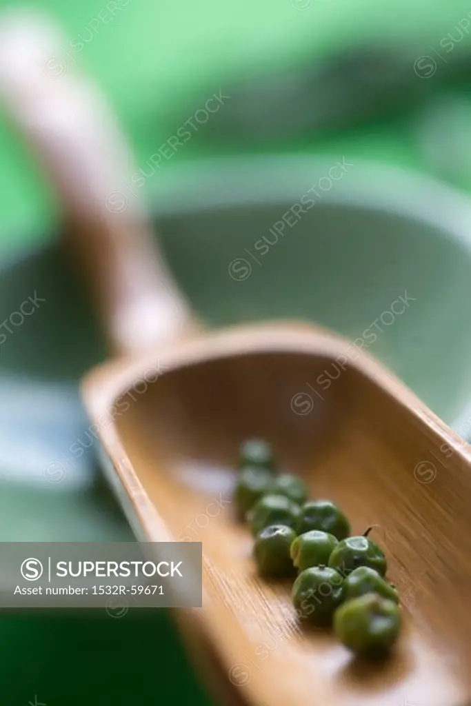 Green peppercorns in a wooden scoop