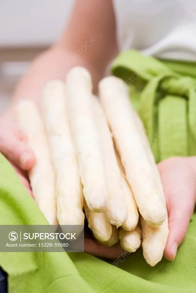 A woman holding white asparagus