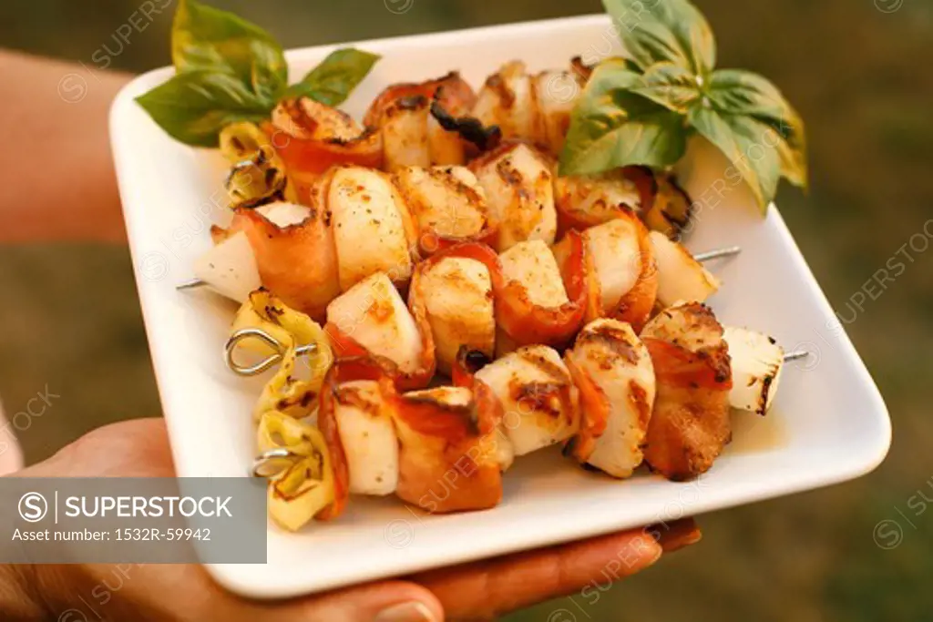 Woman Carrying Plate of Scallop and Bacon Skewers