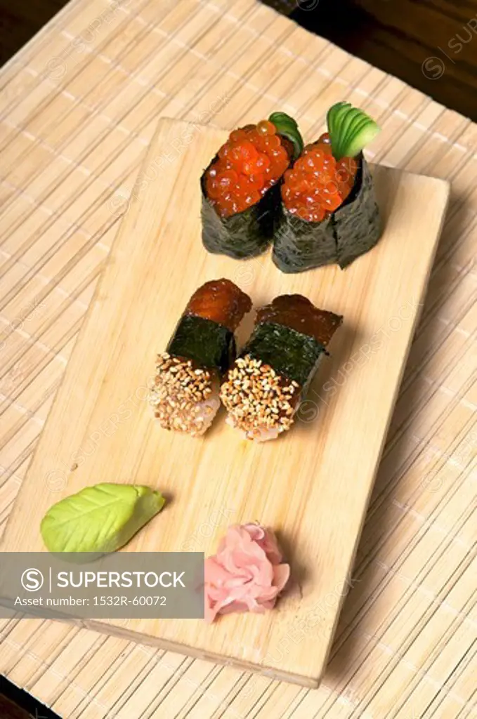 Sushi with mackerel and salmon caviar on a wooden board